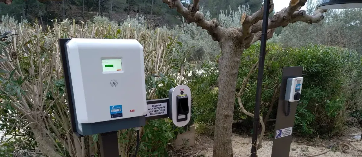 Borne de recharge sur pied installée en extérieur, dans un espace vert d'entreprise