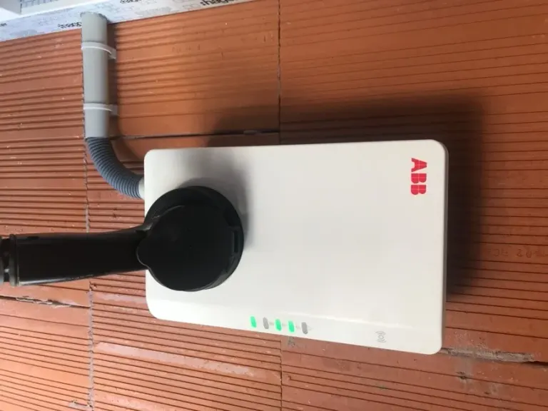 Borne de recharge raccordée en apparent sur une façade, câblage soigné